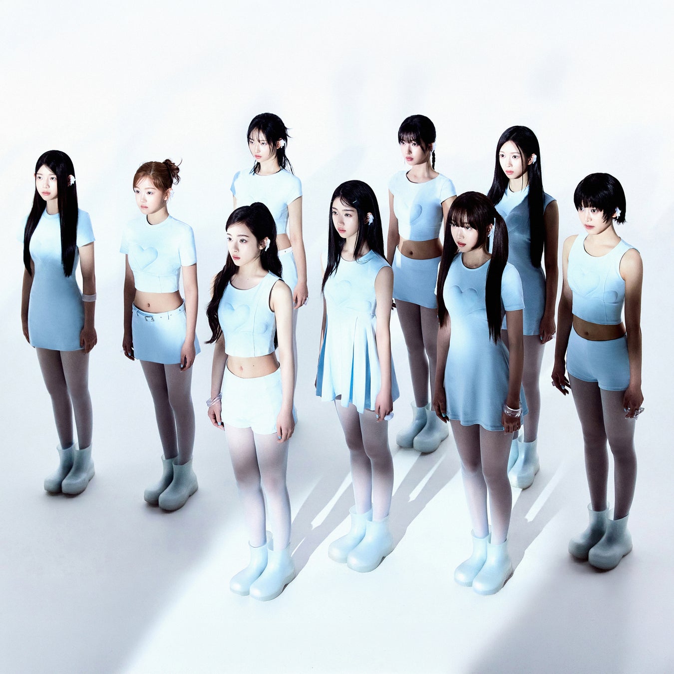 The nine members of A2O LITE in a light-blue group portrait supplied by A2O Entertainment.