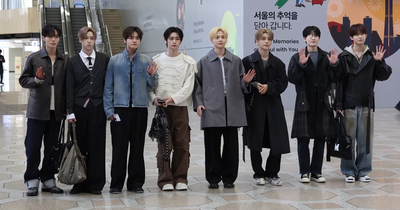 ALPHA DRIVE ONE members at an airport on March 12, 2026, with Geonwoo at the far right.