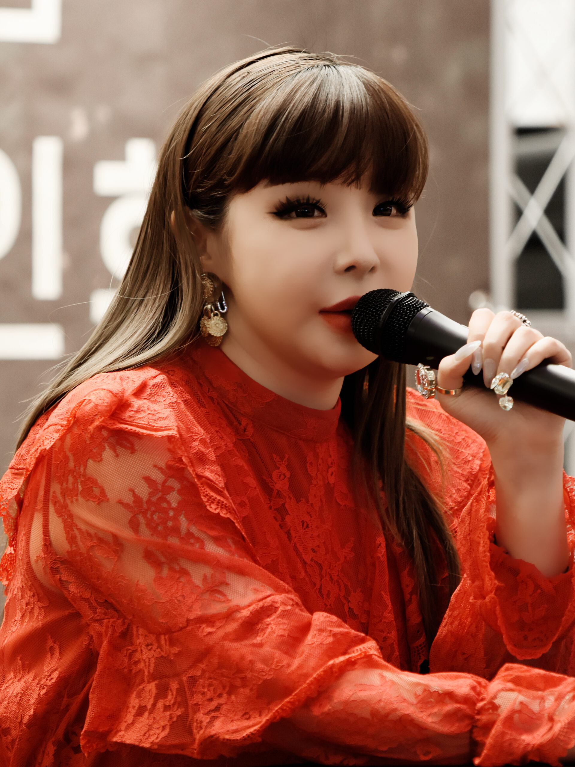 Park Bom holding a microphone at a March 2019 fan signing in Jamsil