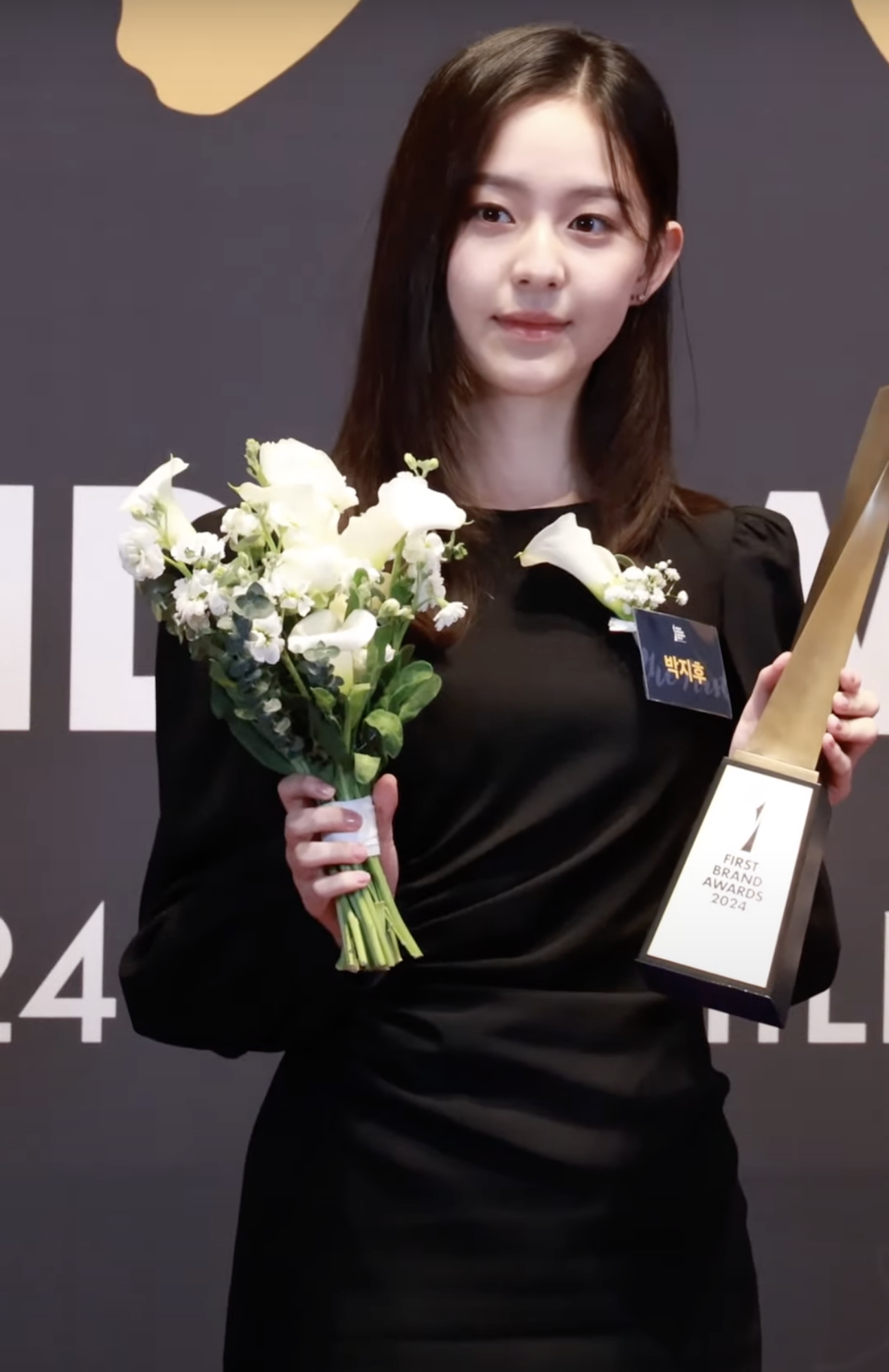 Park Ji-hu holding flowers and a trophy at the First Brand Awards in January 2024